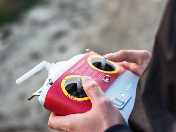 Hands holding a drone remote controller outdoors
